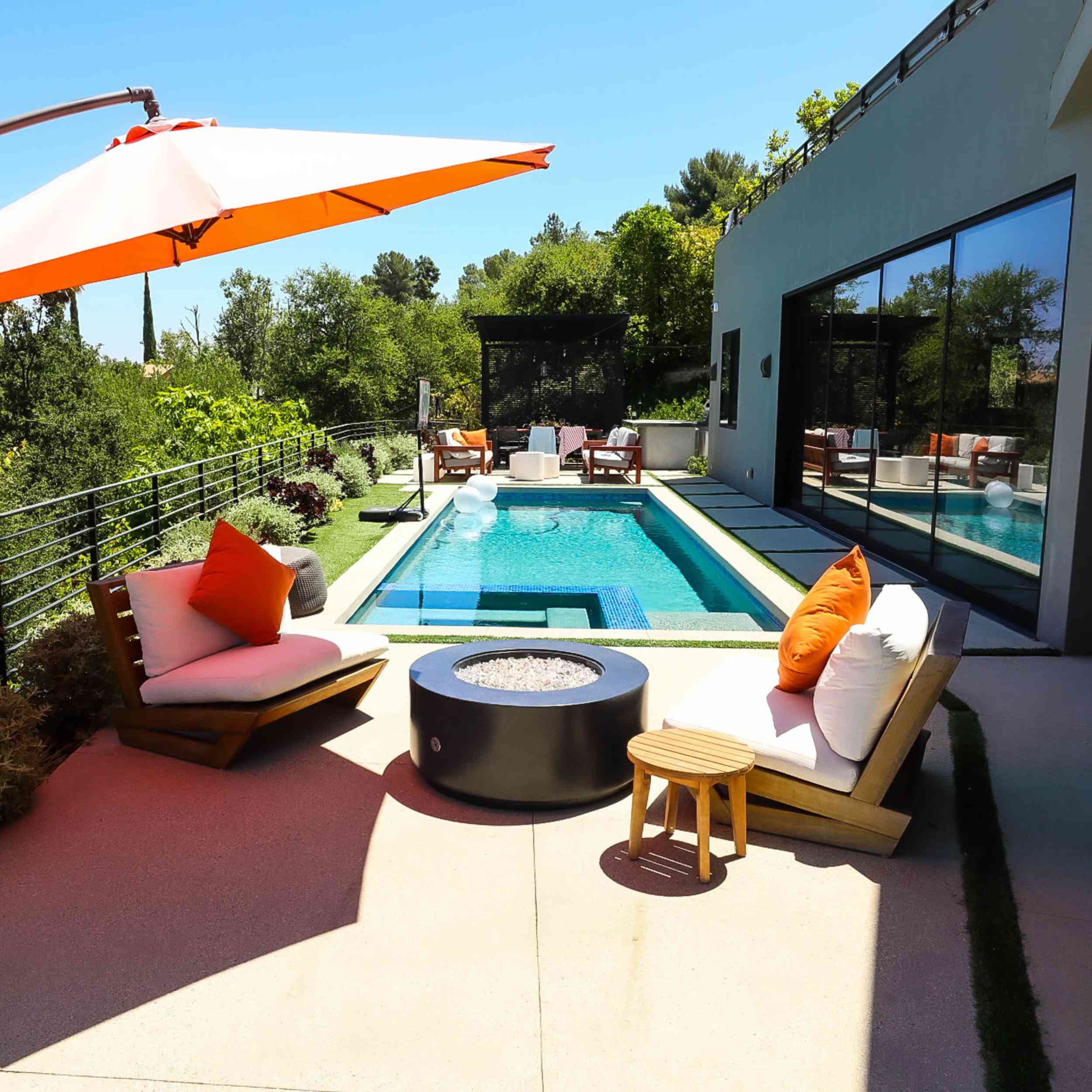 Oblica Black In open area with Orange umbrella beside pool wide shot