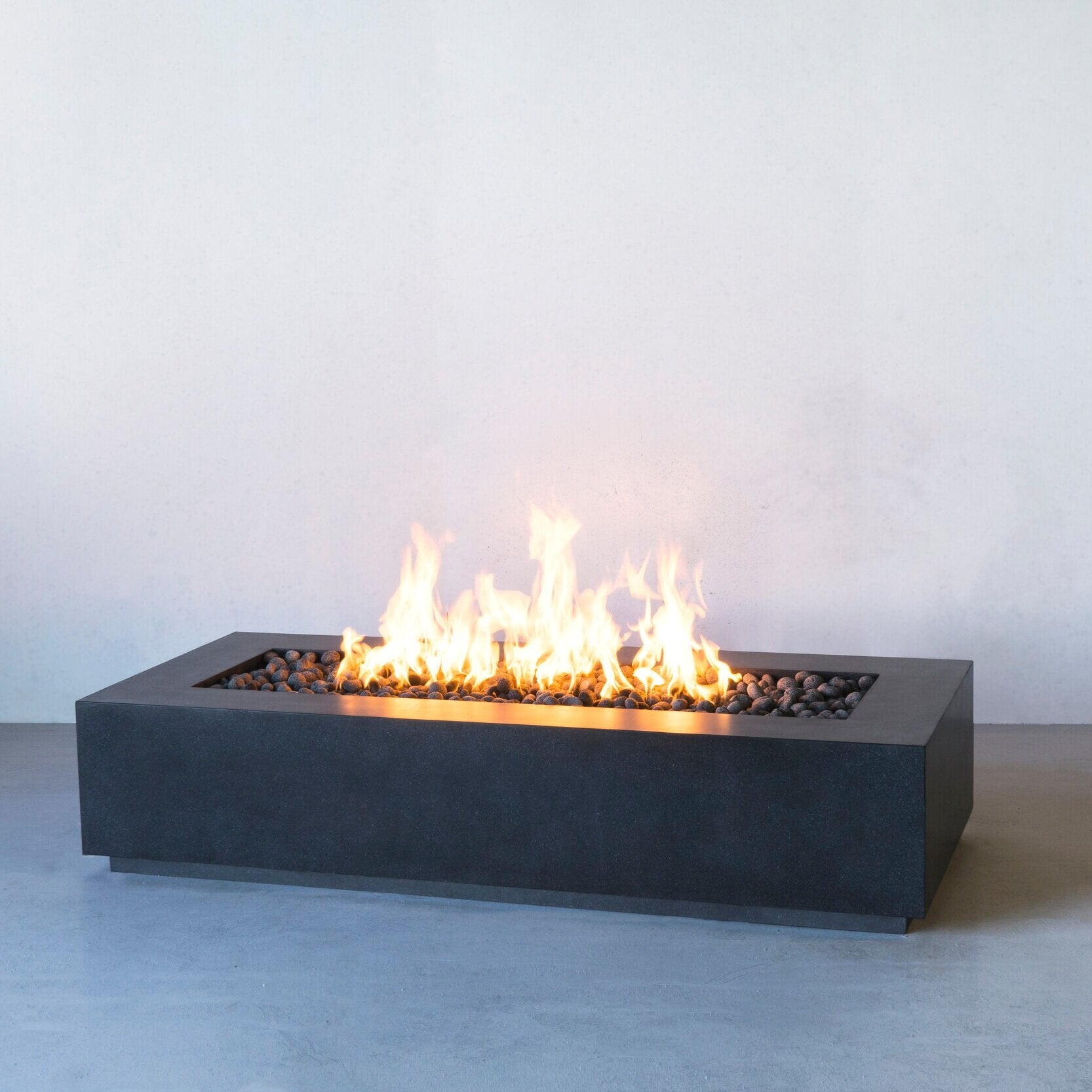 Lumera rectangular concrete firepit in dark gray lifestyle shot