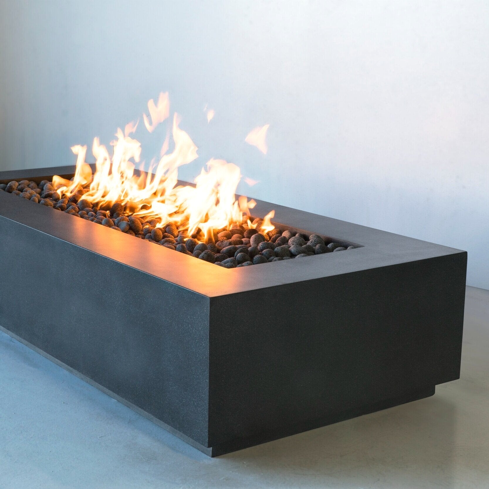 Close up of Lumera rectangular concrete firepit in dark gray lifestyle shot