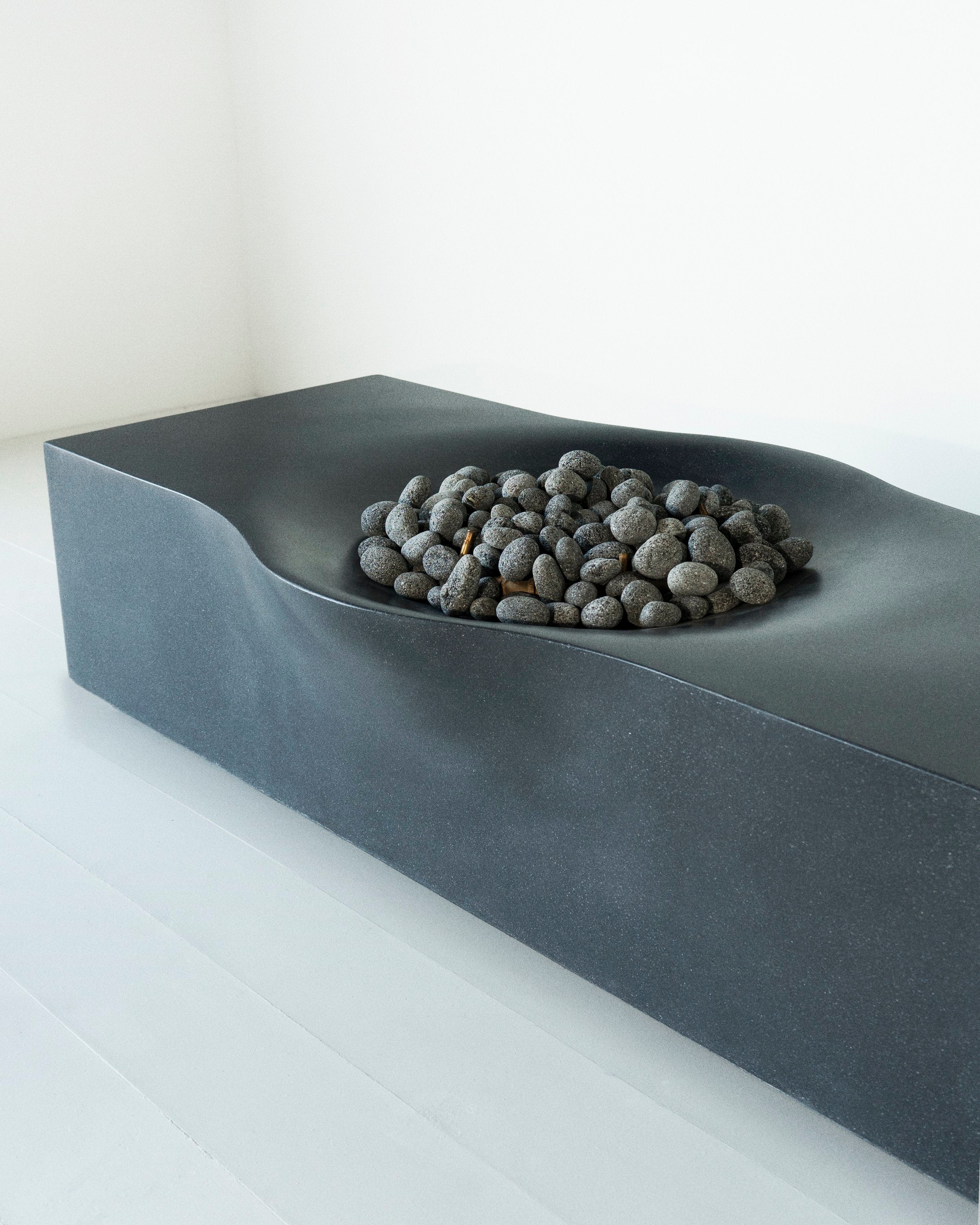 Nido concrete fire pit with small fire pit rocks on top